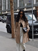 a lady wears a trench coat with a white wide leg jeans